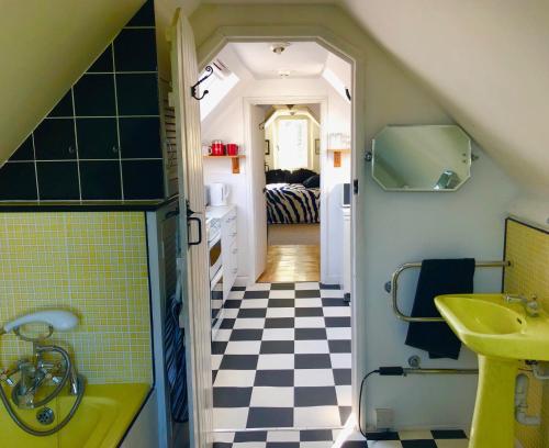 a bathroom with a black and white checkered floor at Lauras Townhouse Apartments Skylight Loft in Bath