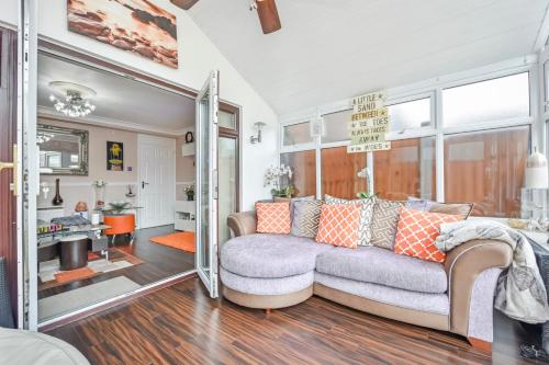 a living room with a couch and a mirror at Docklands Stay, Room in Modern Spacious House - Near Excel Centre, City Airport, UEL,Sleeps 2 in London