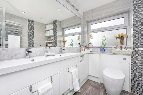 a bathroom with two sinks and a toilet at Docklands Stay, Room in Modern Spacious House - Near Excel Centre, City Airport, UEL,Sleeps 2 in London