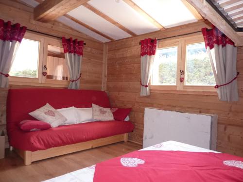 een rode bank in een kamer met ramen bij Chalet Les Lupins in Chamonix-Mont-Blanc