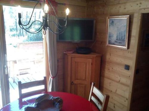 een eetkamer met een tafel en een televisie aan de muur bij Chalet Les Lupins in Chamonix-Mont-Blanc