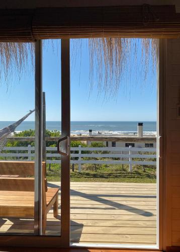 a door to a porch with a view of the ocean at Cabañas Punta Papaya in Punta Del Diablo