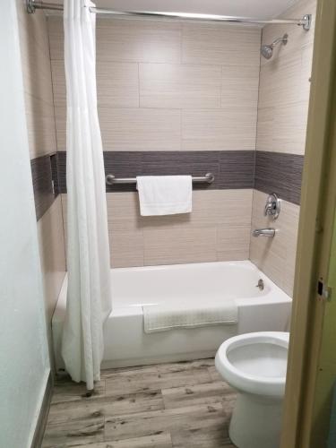 a bathroom with a white tub and a toilet at Americas Best Value Inn & Suites Extended Stay - Tulsa in Tulsa