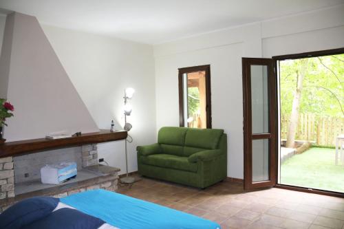 a bedroom with a green chair and a fireplace at Casa Vacanze Il Giardino - Appartamento Nocciolo in Aritzo