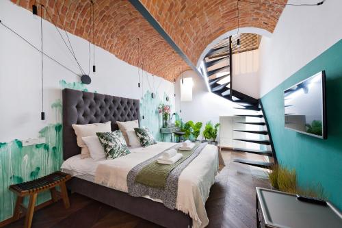 1 dormitorio con 1 cama grande y una escalera en House of LoftAffair, en Cracovia