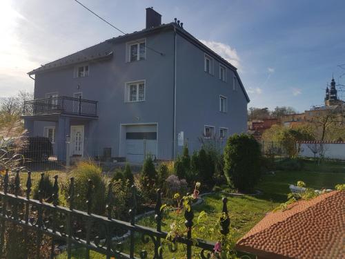 a white house with a fence and a garden at Villa Zdrojowa in Otmuchów