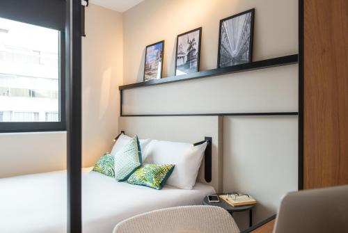 a bedroom with a white bed with a black headboard at ibis Brussels Centre Chatelain in Brussels