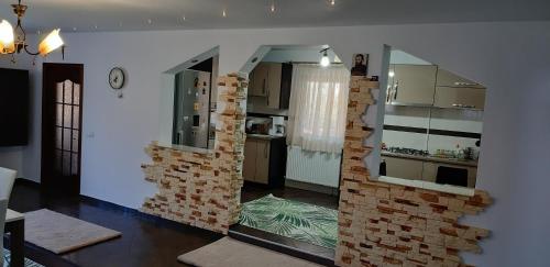 a living room with a brick wall and a kitchen at Casa de vacanta Sabrina in Gura Humorului