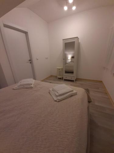 a white room with a bed and a mirror at Apartment Queen in Belgrade