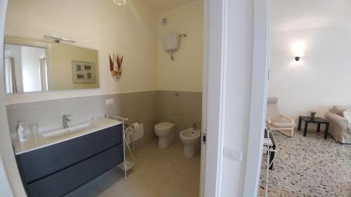 a bathroom with a sink and a toilet and a mirror at San Lucifero Home & Relax - IUN 1871 in Cagliari