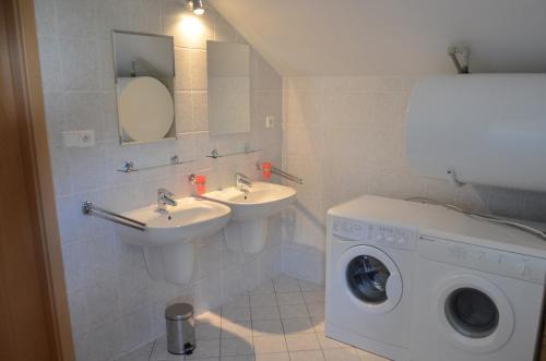 a bathroom with two sinks and a washing machine at Villa Lipno Lake in Lipno nad Vltavou