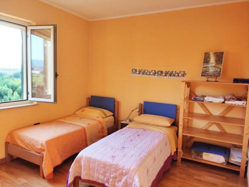 1 Schlafzimmer mit 2 Betten und einem Fenster in der Unterkunft Villetta tra gli agrumeti in Corigliano Calabro