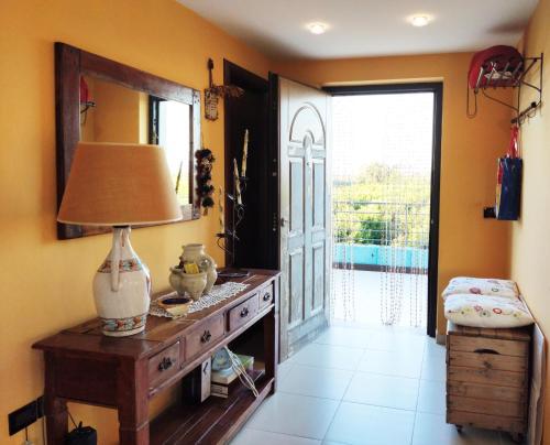 Zimmer mit einem Tisch mit einer Lampe und einer Tür in der Unterkunft Villetta tra gli agrumeti in Corigliano Calabro