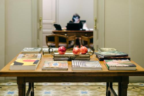 un tavolo in legno con libri e mele sopra di Circa 1905 a Barcellona