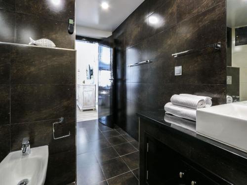 a black bathroom with a sink and a mirror at Luxury Apartment, 3 min Walk to Beach, Albufeira in Guia