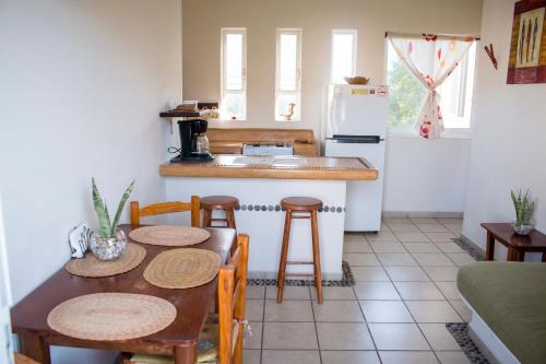 a kitchen with a table and chairs and a refrigerator at Canto del Mar Hotel - Zihuatanejo - Suites con Cocina in Zihuatanejo