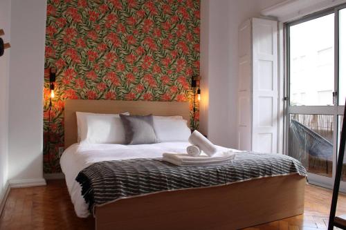 um quarto com uma cama com uma parede vermelha em Bela Casa - Modern Designer Chic Central Coimbra em Coimbra