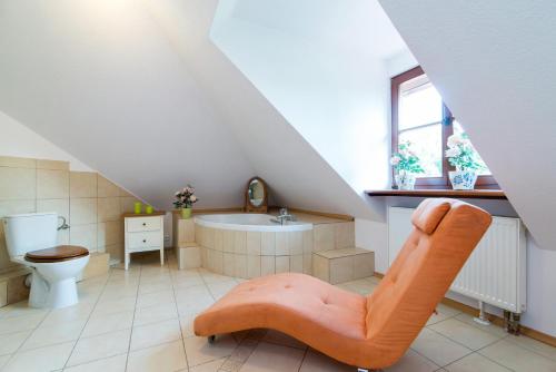 Łazienka na poddaszu z wanną i krzesłem w obiekcie Apartamenty Fenix w Kazimierzu Dolnym