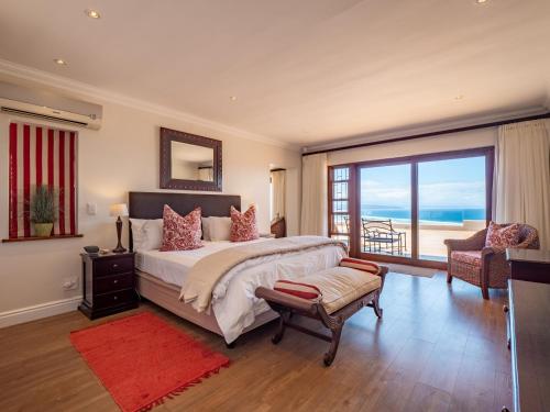 a bedroom with a bed and a view of the ocean at La Vista Lodge in Plettenberg Bay