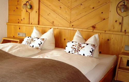 a bedroom with a bed with white pillows at Hotel Garni Apart Elfriede in Fiss