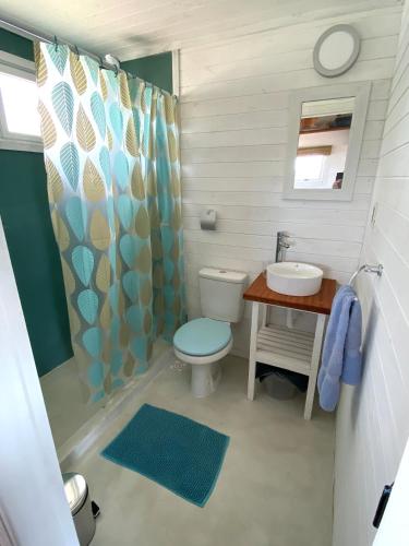 a bathroom with a toilet and a sink at Cabañas Punta Papaya in Punta Del Diablo