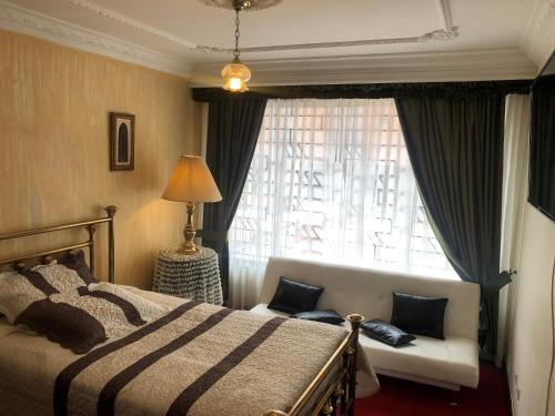 a bedroom with a bed and a window at Casa Morisca/Moorish House in Bogotá