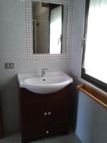 a bathroom with a sink and a mirror at Villino nel Bosco in Capoliveri