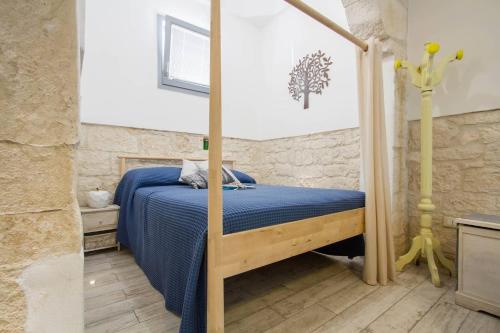Schlafzimmer mit einem Bett mit blauer Decke in der Unterkunft A Casa di Rosy in Ostuni