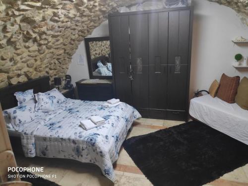 a bedroom with a bed and a stone wall at Jerusalem Old City room in Yerushalayim