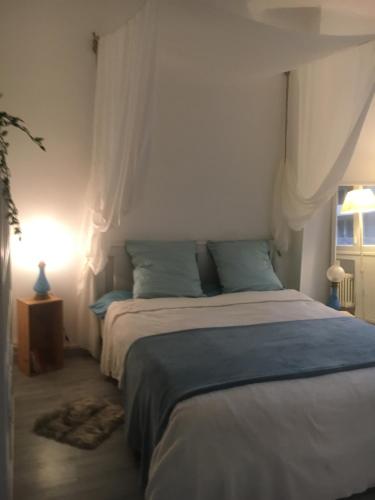 a bedroom with a large bed with blue pillows at Le Lagon Marseillais in Marseille