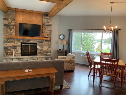 a living room with a couch and a table and a fireplace at Beachfront Inn in Baileys Harbor