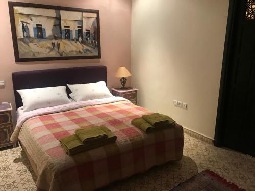 a bedroom with a bed with a checkered blanket at Villa Dar Jbila Tanger in Tangier