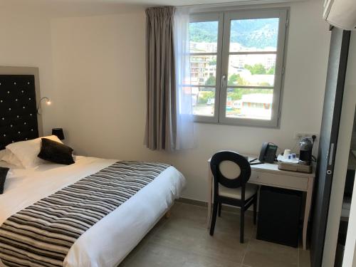 una camera con letto, scrivania e finestra di A STORIA a Bastia
