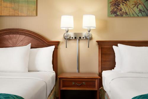 a hotel room with two beds and two lamps at Plim Plaza Hotel in Ocean City