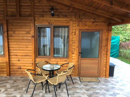 un patio con mesa y sillas frente a una cabaña en Vila Rila, en Sapareva Banya