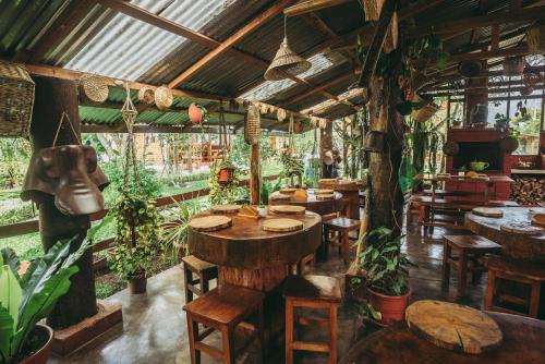 a restaurant with tables and chairs and plants at Posada Edelweiss in Oxapampa