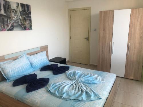 una camera da letto con un letto blu e cuscini sopra di Harmani Beach Sabrina Apartment a Sozopol