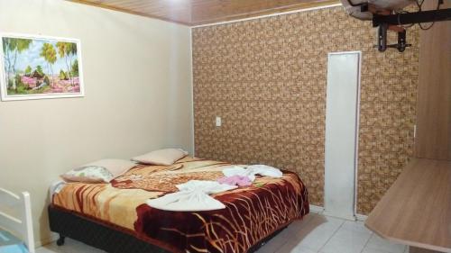 a bedroom with a bed with towels on it at Pousada avenida in Urubici