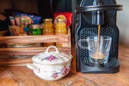 una macchinetta del caffè seduta su un tavolo accanto a una tazza di Goudse Watertoren, ’t kleinste woontorentje van Nederland a Gouda