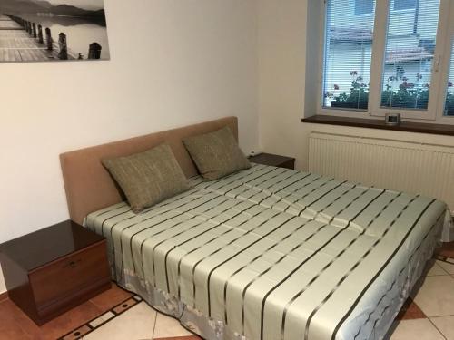a bedroom with a bed in a room with a window at RRR Apartmány in Bojnice