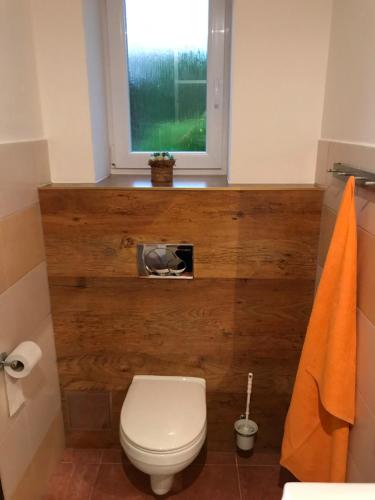 a bathroom with a white toilet and a window at RRR Apartmány in Bojnice