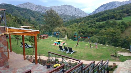 a park with a playground with chairs and a slide at Apartamentos Rurales Balcón Real Senda del Oso in Campiello