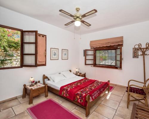 a bedroom with a bed and a ceiling fan at Charming Country House with View in Episkopí- Rethimno