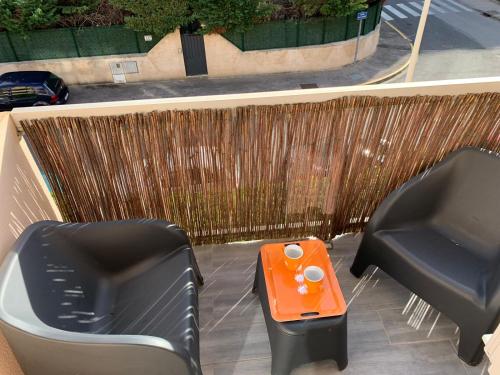 two chairs and an orange table on a patio at Charmant studio avec climatisation et parking in Perpignan