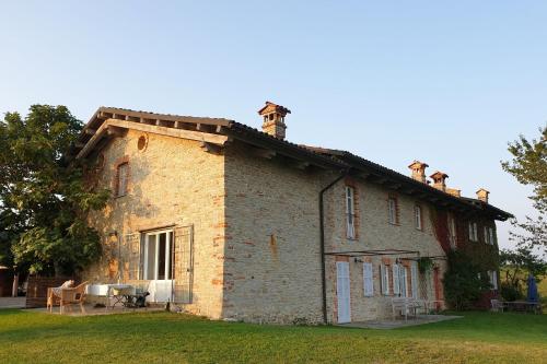 an old brick house with a roof on the grass at Ferrarotti in Clavesana