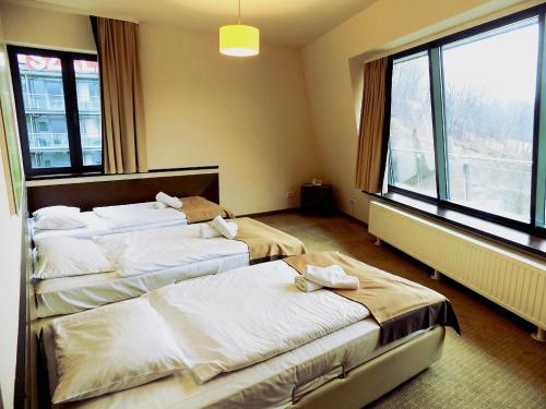 a hotel room with three beds and a large window at Apartament Panoramic in Zakopane