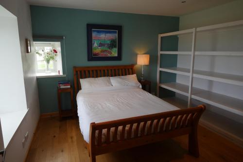 1 dormitorio con cama y pared verde en Macleod Cottage - Isle of Lewis Self-Catering en Port of Ness