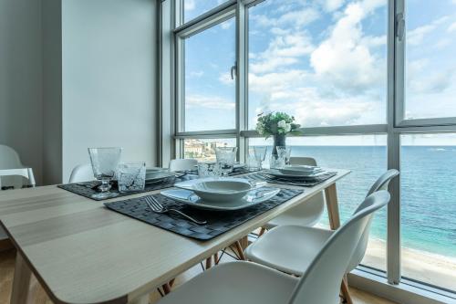 a dining room with a table and a view of the ocean at APARTAMENTO EN PRIMERA LINEA DE PLAYA RiAZOR in A Coruña