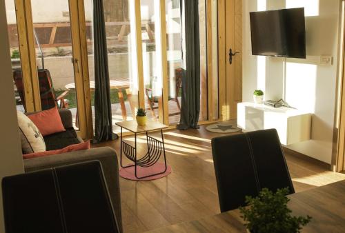 a living room with a television and a table and chairs at Ski and Bike Apartment Rušovc in Kranjska Gora