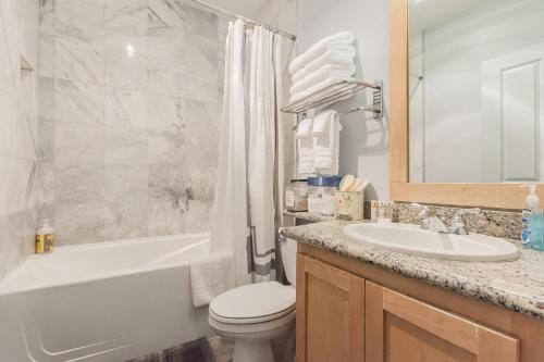 a bathroom with a sink and a toilet and a bath tub at Juniper Springs Lodge #238 in Mammoth Lakes